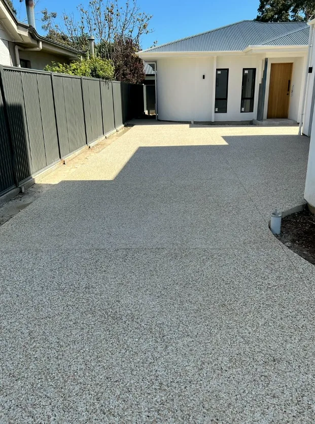 Exposed aggregate driveway running alongside a new home