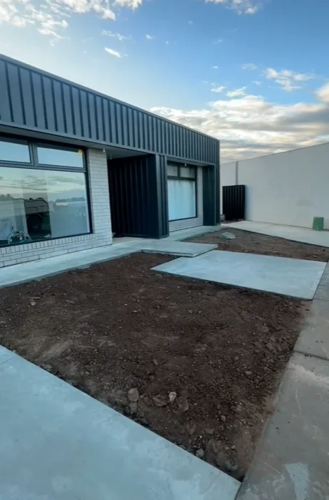 Plain grey concrete pads at the rear of a new home