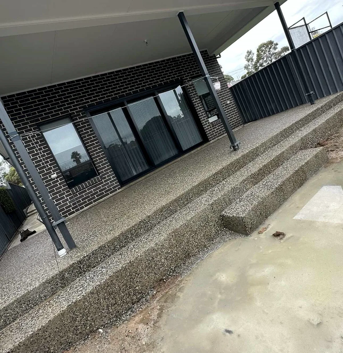 Exposed aggregate entrance step and patio under a verandah